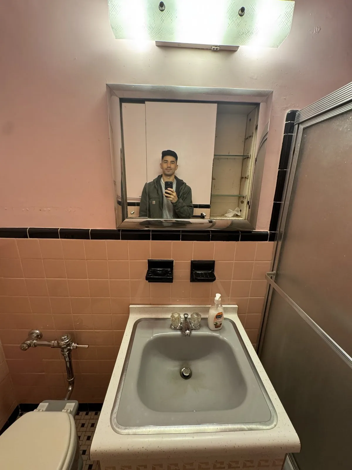 Old wall sink and steel medicine-cabinet mirror in the original bathroom