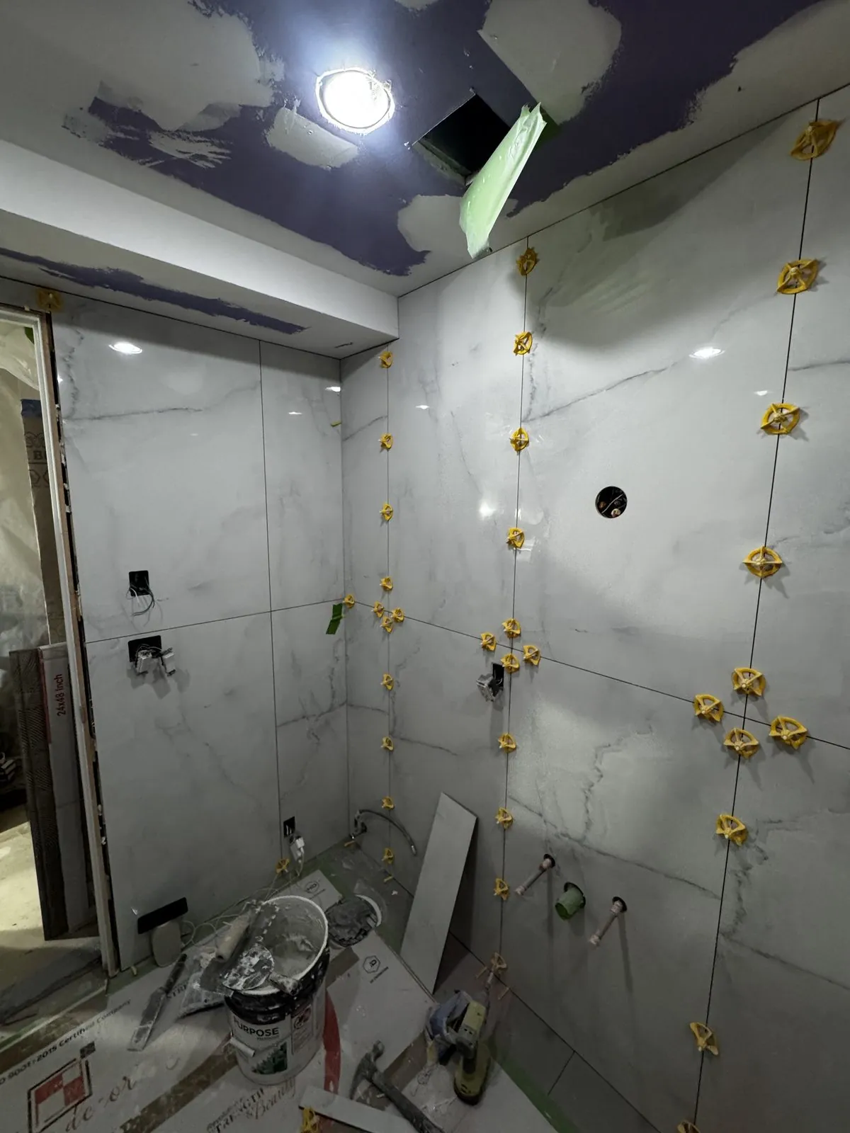 Marble shower walls tiled, recessed niche and curb formed before the glass goes in