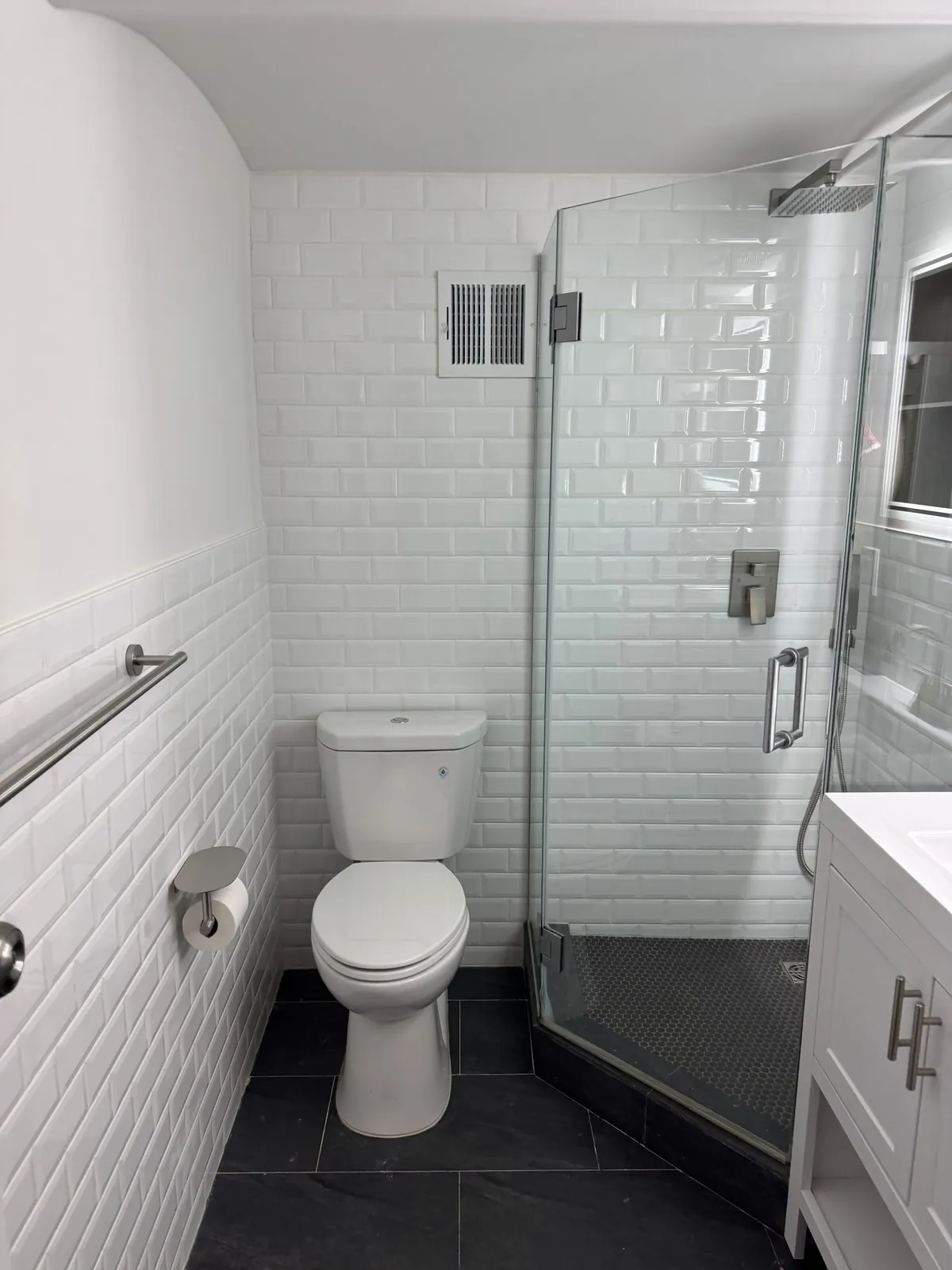 Restored subway-tile bathroom with new glass shower