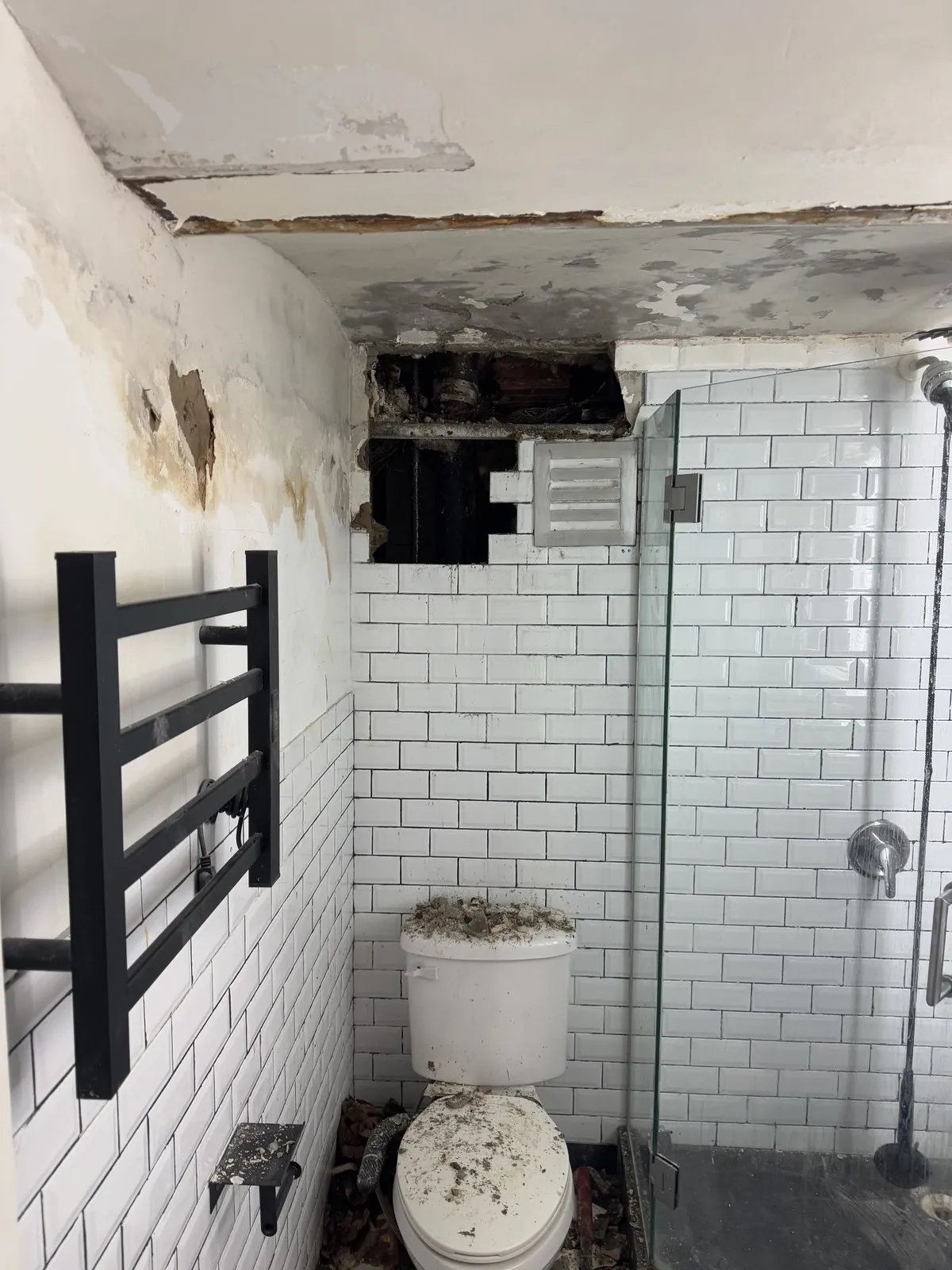 Same bathroom with a water-damaged, collapsed ceiling before the rebuild