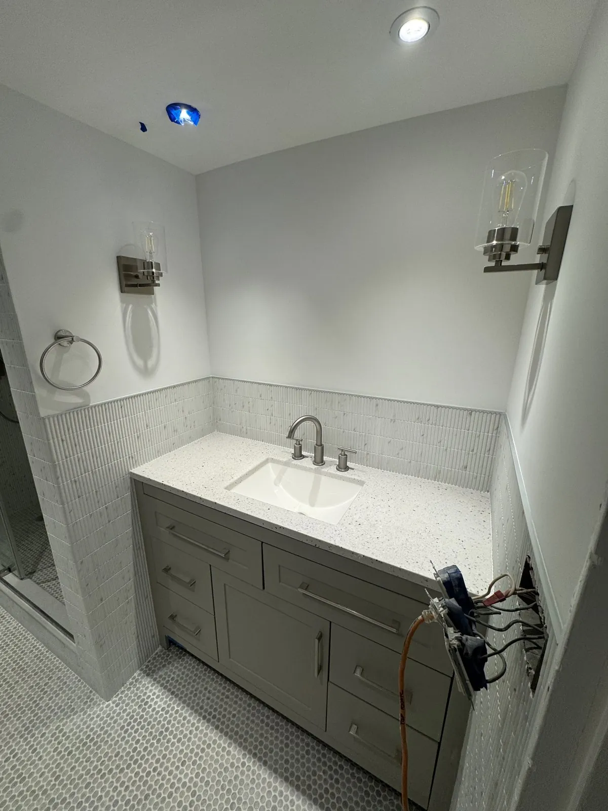 Gray vanity with quartz top and vertical mosaic backsplash