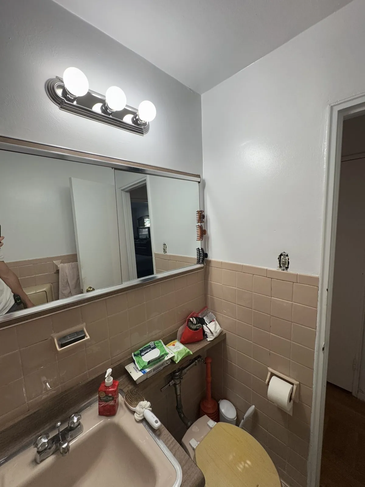 Old vanity, mirror and toilet in the original mauve-tile bathroom