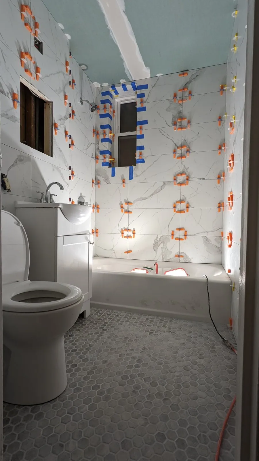White marble walls being set with leveling clips