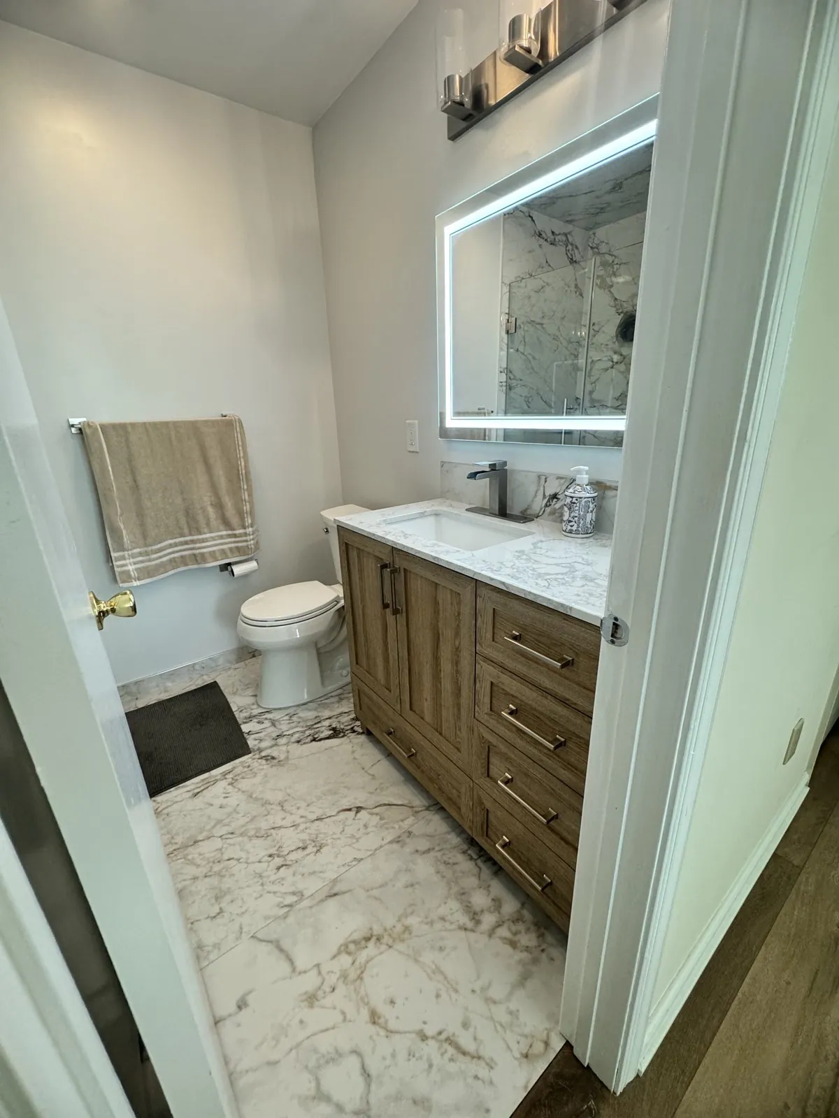 Calacatta marble bathroom with a walk-in shower and walnut vanity