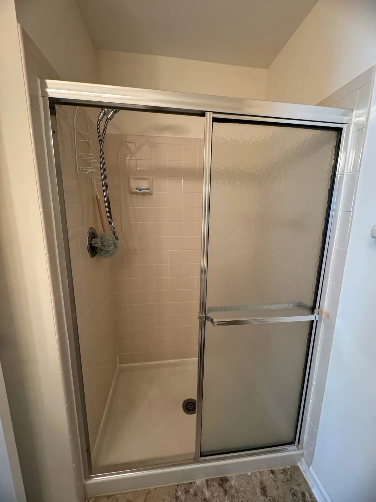 Original framed sliding-glass tub enclosure with dated tile before the gut
