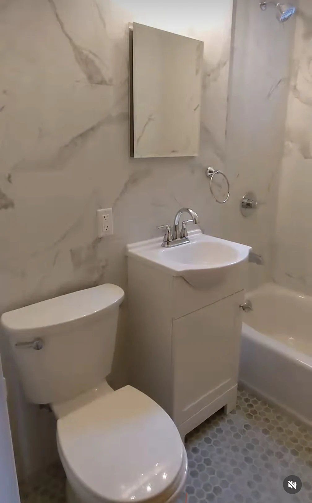 Manhattan apartment bathroom — marble walls, white vanity, tub